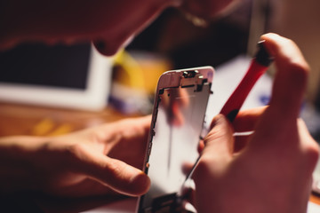 A close-up process of disassemble and dismantle modern mobile phone smartphone with broken...