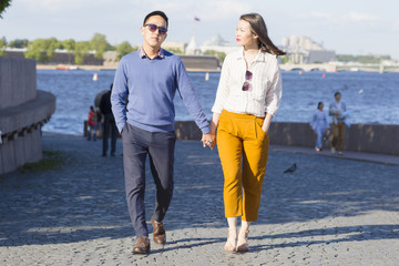 Fototapeta premium A loving couple walk on embankment of a river 