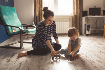 young pregnant mother and son playing on floor, lifestyle,