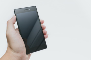 male hand hold black smart phone with blank gross screen composition space for text.