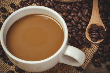 Fototapeta premium Hot Coffee cup with Coffee beans on the wooden table and the bla