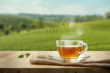 Warm cup of tea and tea leaf and sack on the wooden table and th