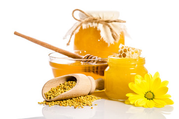 The jars of honey, one of them with honeycombs, glass bowl with