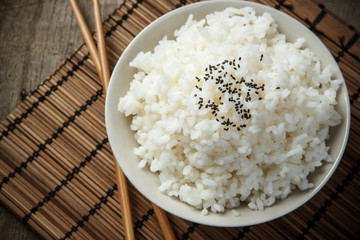 Japan rice and black sesame seeds with chopsticks on a bamboo ma