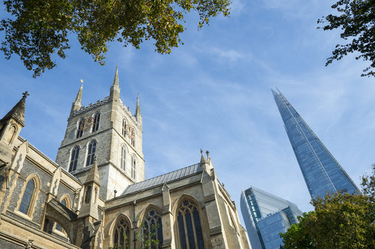 London skyline featuring the old architecture of the Southwark Cathedral with the modern Shard skyscraper beyond