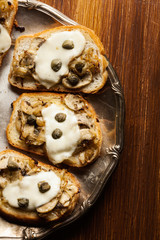 Crostini with fried mushrooms, onion and mozzarella cheese