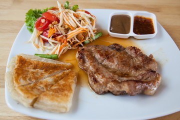 Pork steak with roti and Thai papaya salad.