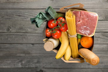 Paper bag of groceries on wooden background