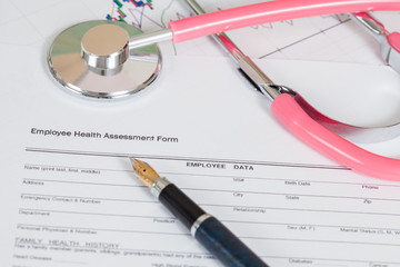 close up employee health assessment form and stethoscope