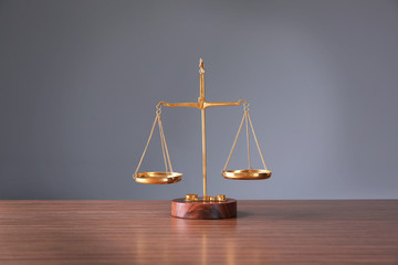 Justice scales on wooden table and  grey background