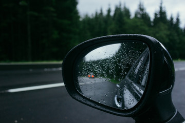 Rain drops on car side view mirror