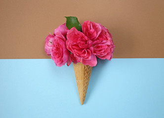 flower ice cream. Roses in a waffle cup on a mixed blue and brown background