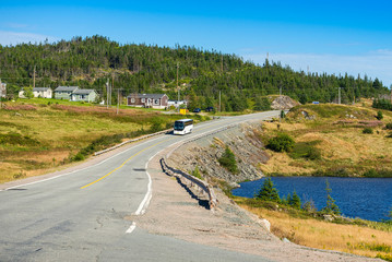 Tour bus driving on a coastal road in central Newfoundland