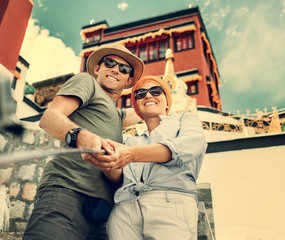 Tourist couple take a self photo on tibetian sight background