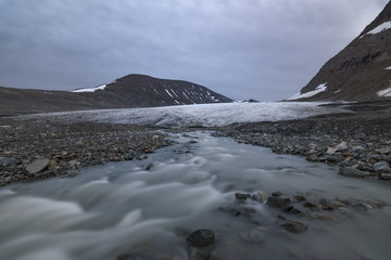 Serene glacier with river arising underneath, Sarek national park, Sweden