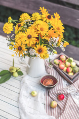  Still, yellow flowers with a vase with apples