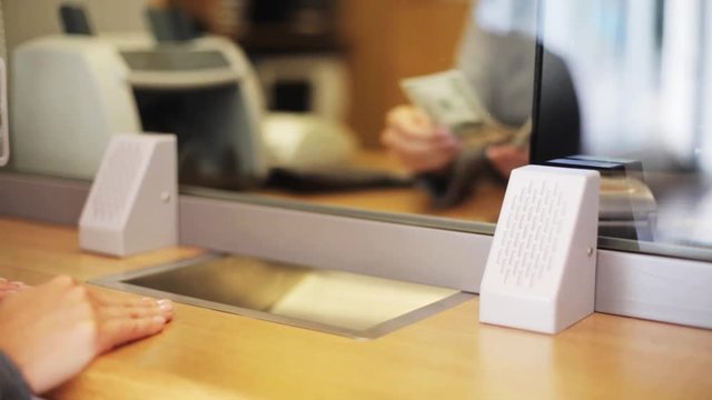 clerk counting money and customer at bank office