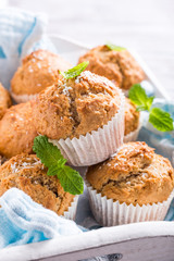 Delicious homemade coconut cinnamon muffins and mint leafs on old white tray. Healthy food concept.
