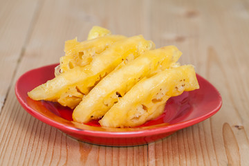 Pineapple in red plate on wood
