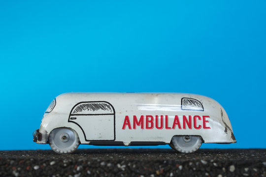 Ambulance vintage toy car on blue background