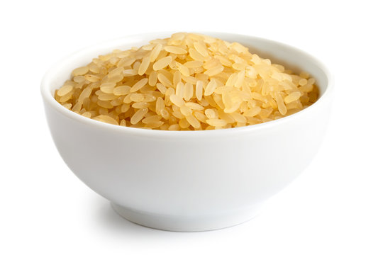 Bowl of short grain parboiled rice isolated on white.