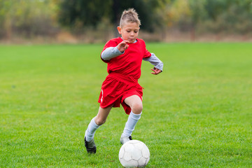 Boy kicking soccer ball