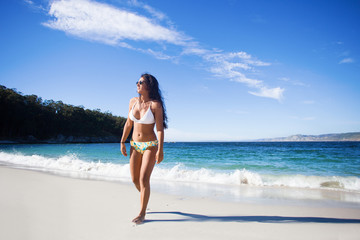 Fototapeta na wymiar young woman walking in the beach