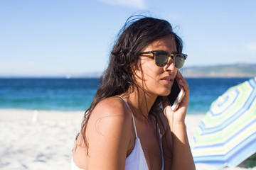 young woman talking on telephone in the beach