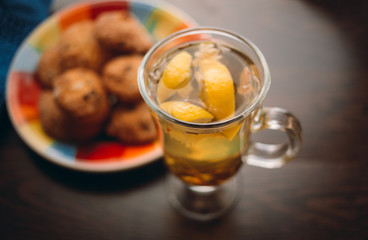 Autumn Still Life: Herbal tea on a wooden table near the window. The sun's rays on a cup of brewed tea. A cup of hot chayas pichenem on a sunny day on the background of the window. Autumn tea