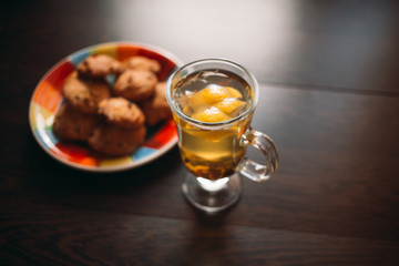 Autumn Still Life: Herbal tea on a wooden table near the window. The sun's rays on a cup of brewed tea. A cup of hot chayas pichenem on a sunny day on the background of the window. Autumn tea