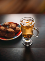 Autumn Still Life: Herbal tea on a wooden table near the window. The sun's rays on a cup of brewed tea. A cup of hot chayas pichenem on a sunny day on the background of the window. Autumn tea
