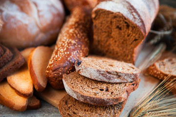 Assortment of fresh baked bread on wooden table background