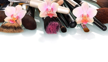 Cosmetic Makeup Brush and orchid flowers isolated on white.