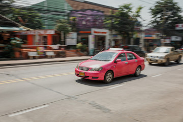 Fototapeta na wymiar Bright car goes through the city of Pattaya, Thailand, Asia