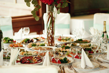 Tasty snacks with vegetables and meat stand on the round table