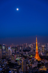 Red Tokyo tower with the moon in the twilight scene and city view