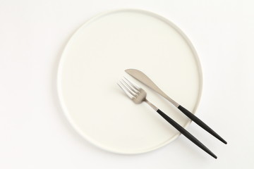 Knife, fork and plate isolated on white background