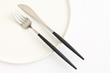 Knife, fork and plate isolated on white background