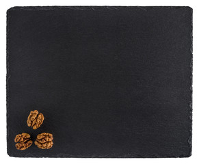 Walnut on a black slate board. Isolated on white background.