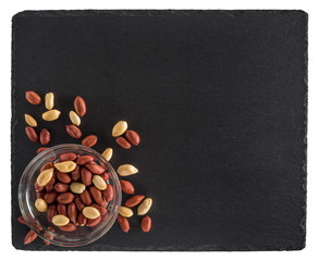 Peanuts in a glass bowl and on a slate blackboard. Isolated on w