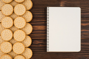 Cookies with a notebook on an old dark table.