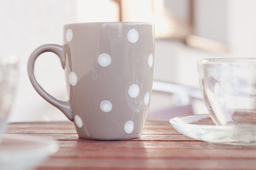 Grey polka dot cup on the round wooden table