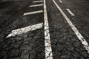 Crack asphalt road on arrow background.