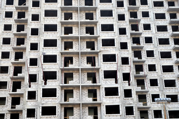 Front view of high-rise modern apartment building construction in process front view horizontal