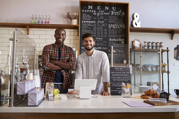 Business partners stand behind the counter at a coffee shop