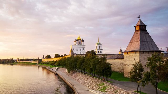 Pskov Kremlin at sunset. Time-lapse of a colorful sky over a river and promenade area