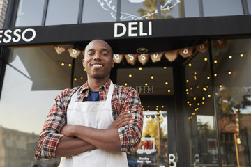 Black male business owner standing outside coffee shop - obrazy, fototapety, plakaty