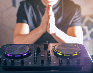 DJ turntable console mixer controlling with two hand in concert nightclub stage.