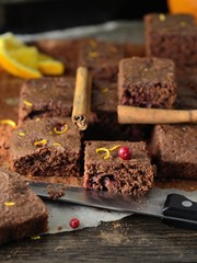 Pieces of freshly baked brownie with oranges, cinnamon, cranberries