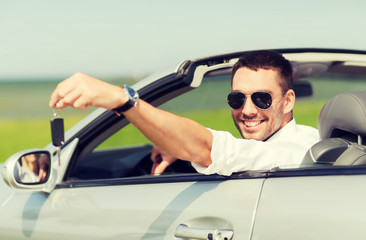 happy man in cabriolet showing car key